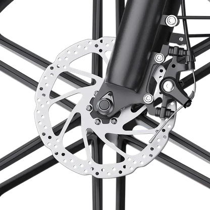 Close-up of a bicycle disc brake with a perforated rotor and black caliper on black spokes
